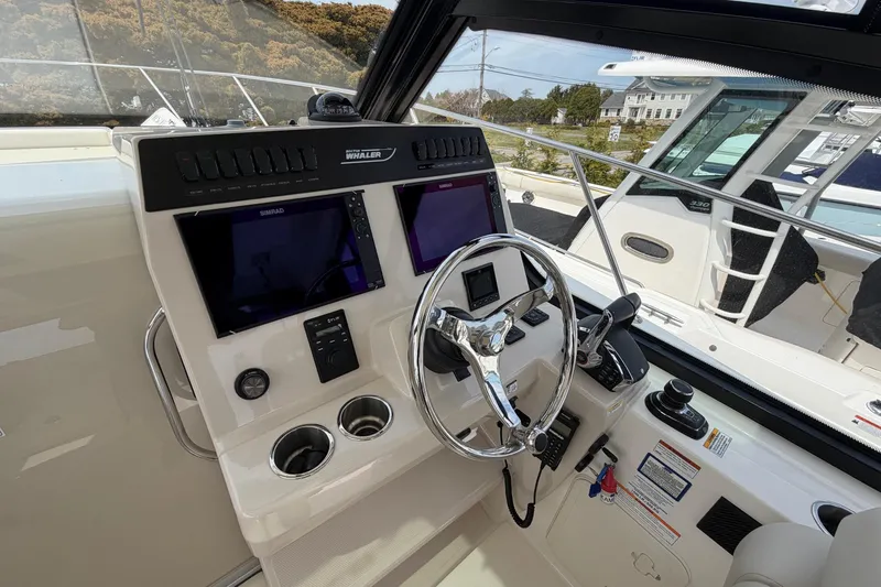 Slide: The Image of Helm of 2023 Boston Whaler 325 Conquest with advanced navigation displays and controls. - 21