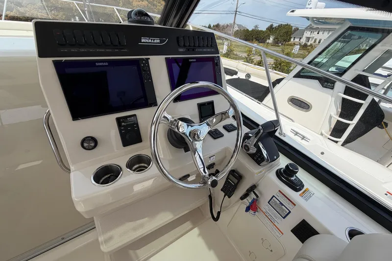 Slide: The Image of 2023 Boston Whaler 325 Conquest helm with dual Simrad displays and modern controls. - 22