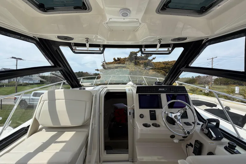 Slide: The Image of 2023 Boston Whaler 325 Conquest helm with modern controls and panoramic windows. - 23
