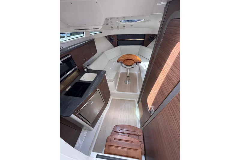 Slide: The Image of Interior of 2023 Boston Whaler 325 Conquest, featuring modern kitchen and seating area. - 24