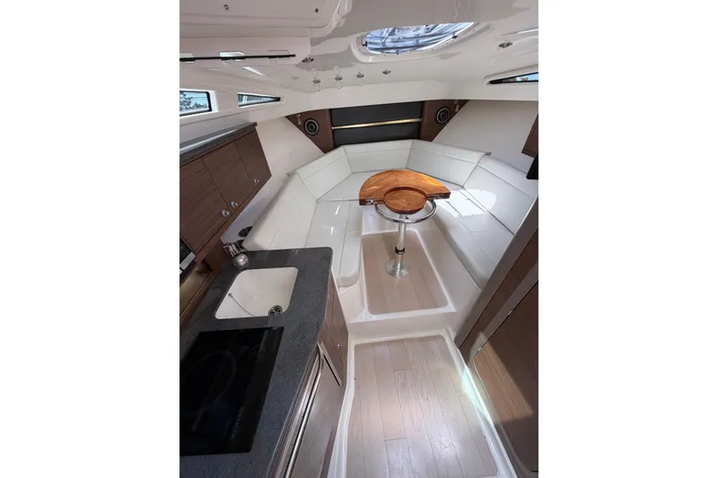 Slide: The Image of Interior of 2023 Boston Whaler 325 Conquest, featuring modern seating and compact kitchenette. - 27