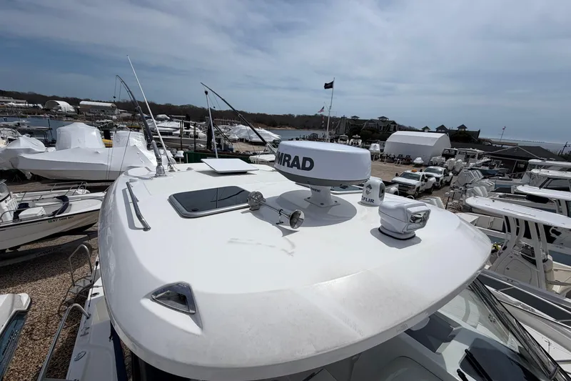 Slide: The Image of 2023 Boston Whaler 325 Conquest boat docked at a marina, showcasing radar equipment. - 33