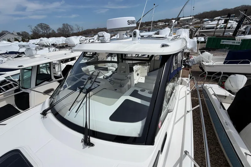 Slide: The Image of 2023 Boston Whaler 325 Conquest boat docked, showcasing sleek design and advanced navigation equipment. - 35