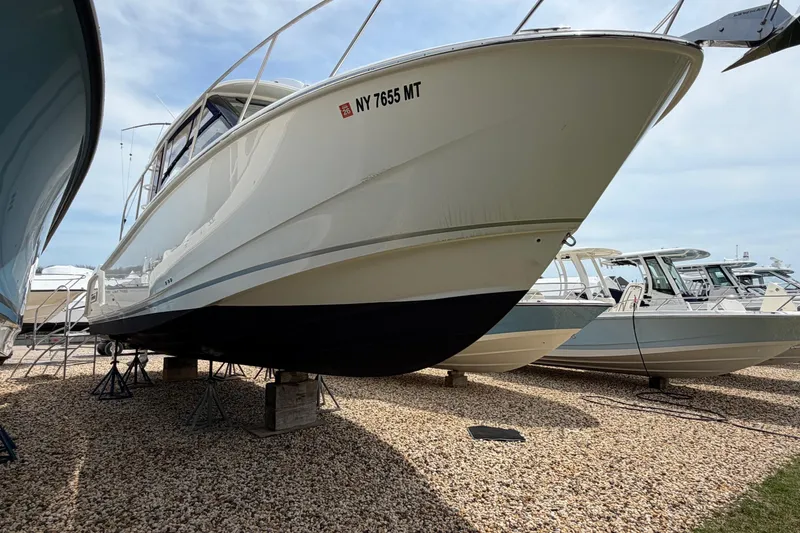 Slide: The Image of 2023 Boston Whaler 325 Conquest boat on display, elevated on stands. - 36