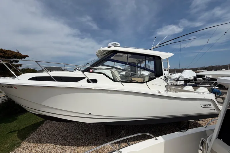 Slide: The Image of 2023 Boston Whaler 325 Conquest boat displayed outdoors under a clear sky. - 40