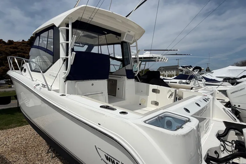 Slide: The Image of 2023 Boston Whaler 325 Conquest boat docked, showcasing sleek design and spacious deck. - 41