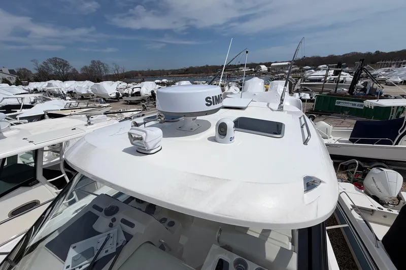 Slide: The Image of 2023 Boston Whaler 325 Conquest boat with radar and navigation equipment docked at marina. - 43