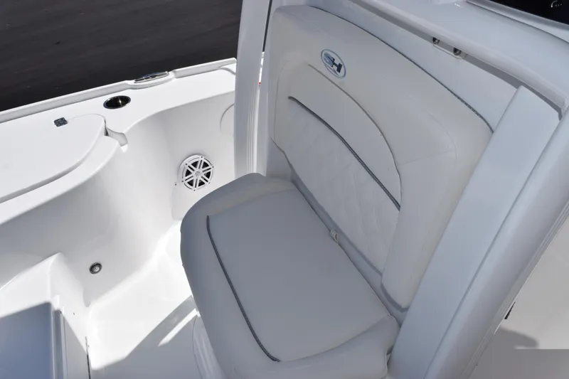 Slide: The Image of 2026 Sea Hunt BX 22 BR boat interior with white cushioned seating and speaker. - 12