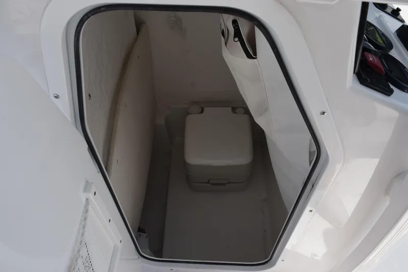 Slide: The Image of Storage compartment inside 2026 Sea Hunt BX 22 BR boat, featuring a compact portable toilet. - 17