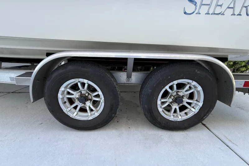 Slide: The Image of Trailer wheels of a 2023 ShearWater x22 boat on a concrete surface. - 11