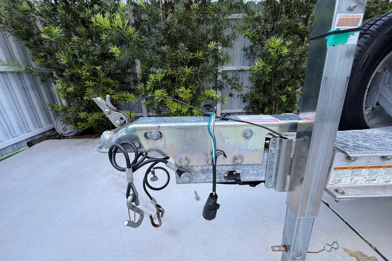 Slide: The Image of Trailer hitch of a 2023 ShearWater x22, featuring wiring and safety chains. - 14