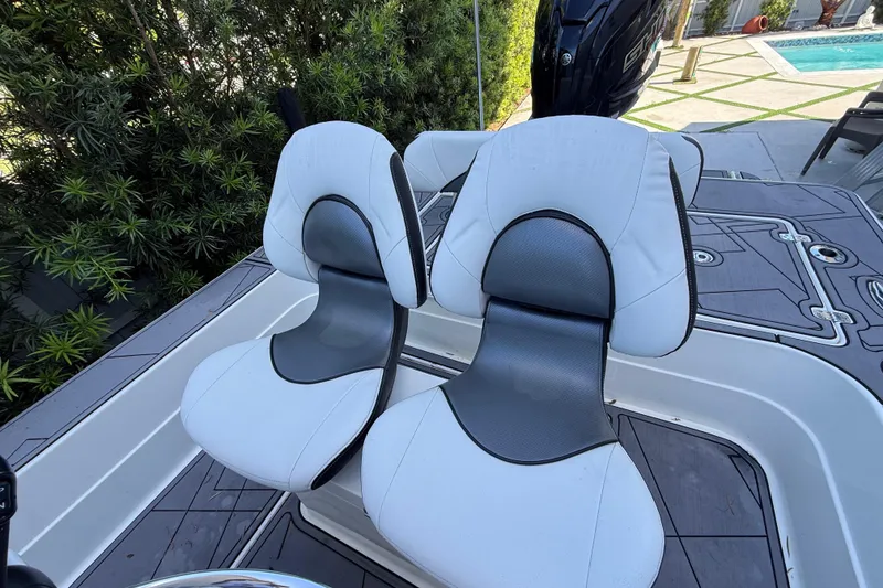 Slide: The Image of Two white and gray seats on a 2023 ShearWater x22 boat deck. - 22