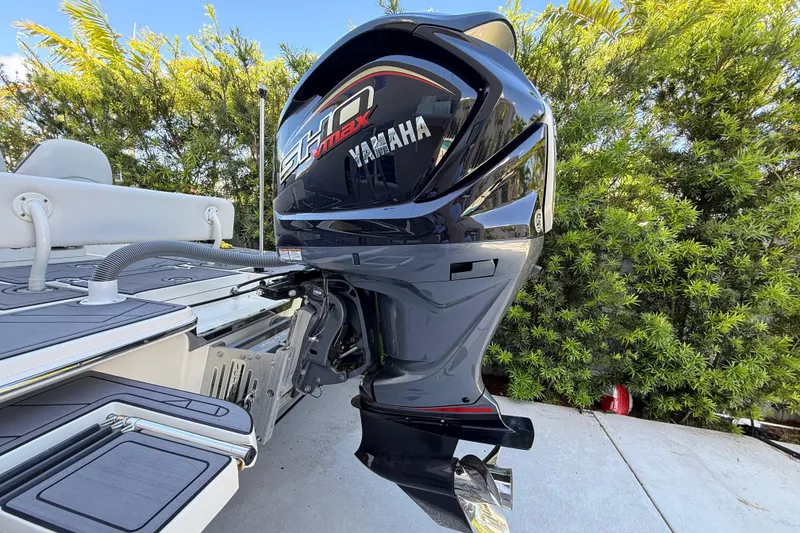 Slide: The Image of 2023 ShearWater x22 boat with Yamaha SHO VMAX outboard motor, docked near lush greenery. - 4