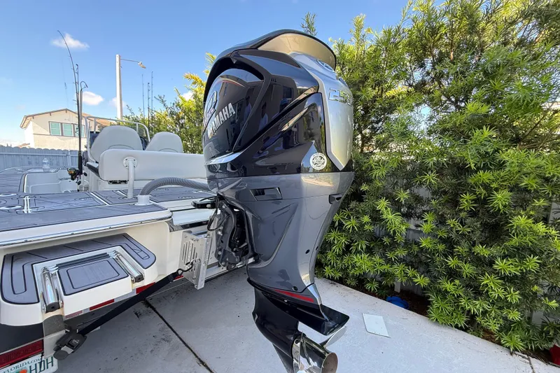 Slide: The Image of 2023 ShearWater x22 boat with Yamaha outboard motor, parked near greenery. - 7