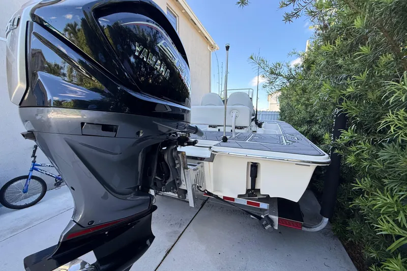 Slide: The Image of 2023 ShearWater x22 boat with Yamaha engine parked beside greenery. - 8