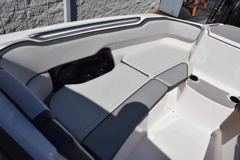 Slide: The Image of 2024 Yamaha Boats AR250 interior seating with cup holders and sleek design. - 15