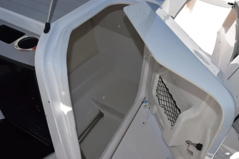 Slide: The Image of 2024 Yamaha Boats AR250 storage compartment with open hatch and netting. - 17