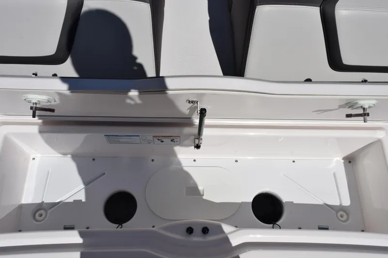 Slide: The Image of 2024 Yamaha Boats AR250 storage compartment with open lid, showcasing interior details. - 24