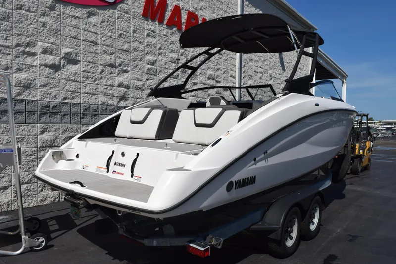 Slide: The Image of 2024 Yamaha Boats AR250 on trailer, sleek design, parked outside dealership. - 4
