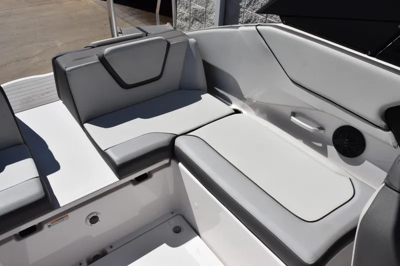 Slide: The Image of 2024 Yamaha Boats AR250 interior seating with sleek gray upholstery and integrated speaker. - 9