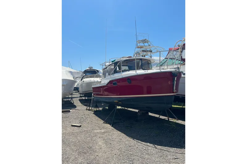 The Image of 2018 Ranger Tugs R-23 boat in dry dock, vibrant red hull, sunny day. - 0