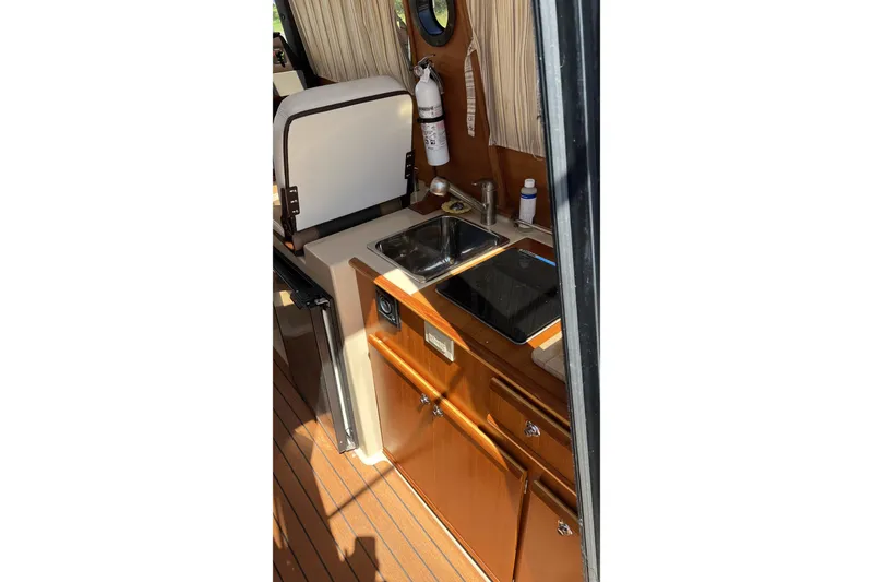 Slide: The Image of Compact kitchen area in 2018 Ranger Tugs R-23 boat with sink and stove. - 13