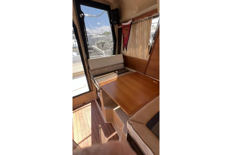 Slide: The Image of Interior of 2018 Ranger Tugs R-23 boat with wooden table and seating area. - 16