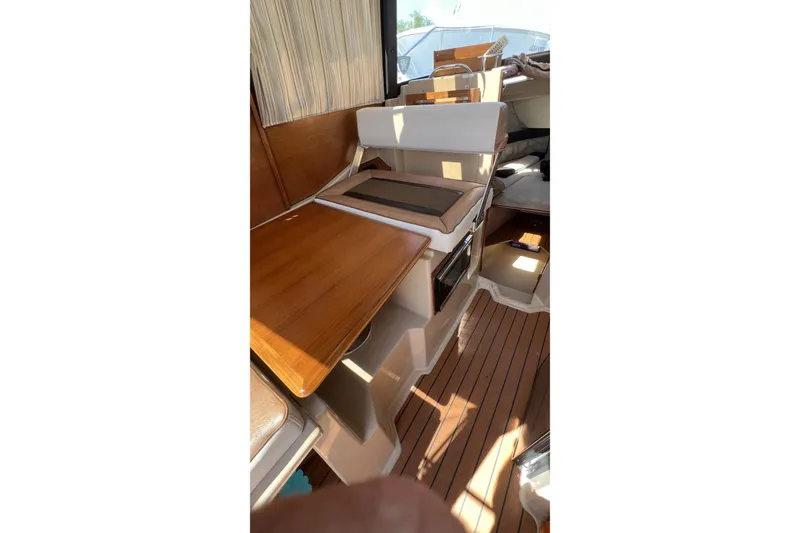 Slide: The Image of Interior of 2018 Ranger Tugs R-23 boat with wooden table and seating area. - 18