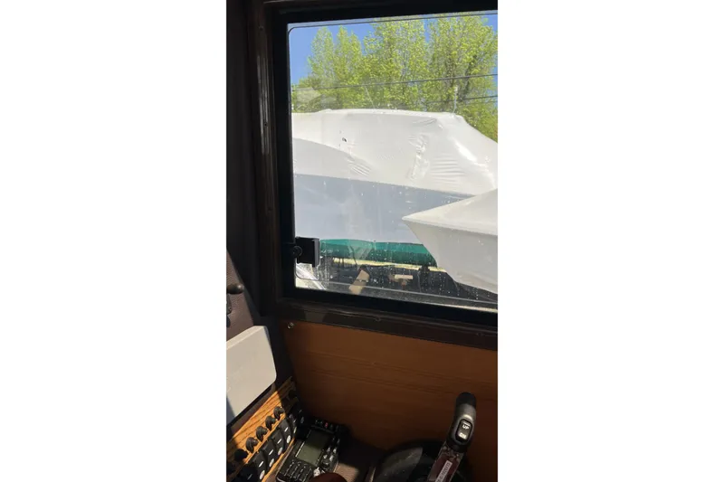 Slide: The Image of Interior view from a 2018 Ranger Tugs R-23, looking out at wrapped boats. - 25