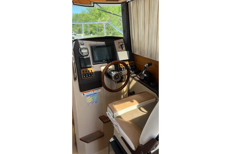 Slide: The Image of 2018 Ranger Tugs R-23 helm with steering wheel, controls, and navigation display. - 26