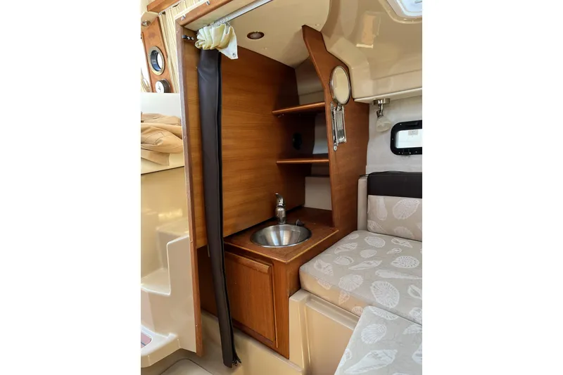 Slide: The Image of 2018 Ranger Tugs R-23 interior with wooden cabinetry and compact sink. - 27