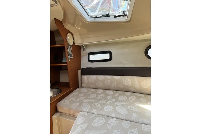 Slide: The Image of Interior cabin of 2018 Ranger Tugs R-23 with patterned cushions and porthole window. - 28