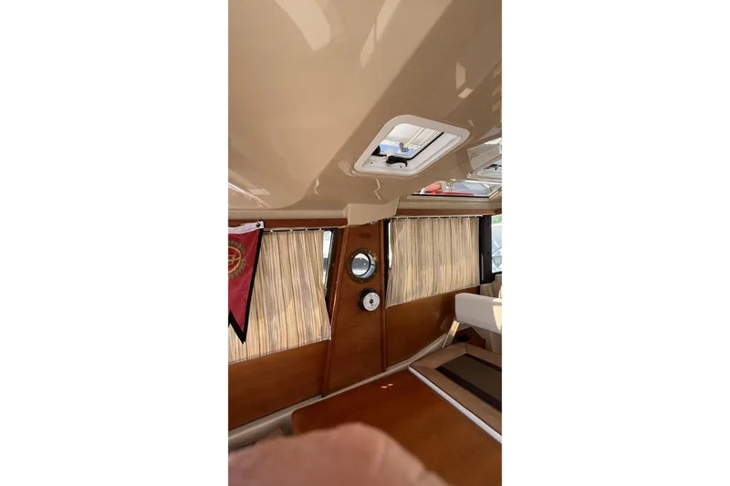 Slide: The Image of Interior of 2018 Ranger Tugs R-23 boat with wood paneling and curtains. - 29