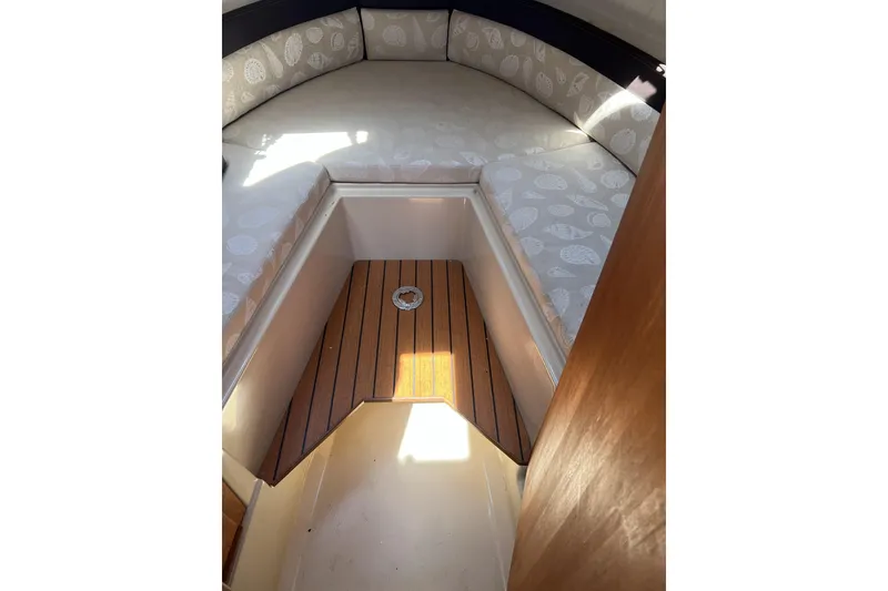 Slide: The Image of 2018 Ranger Tugs R-23 cabin interior with cushioned seating and wooden flooring. - 31