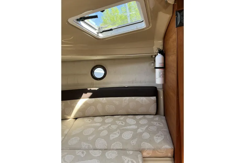 Slide: The Image of Interior cabin of 2018 Ranger Tugs R-23 with patterned cushions and porthole window. - 32