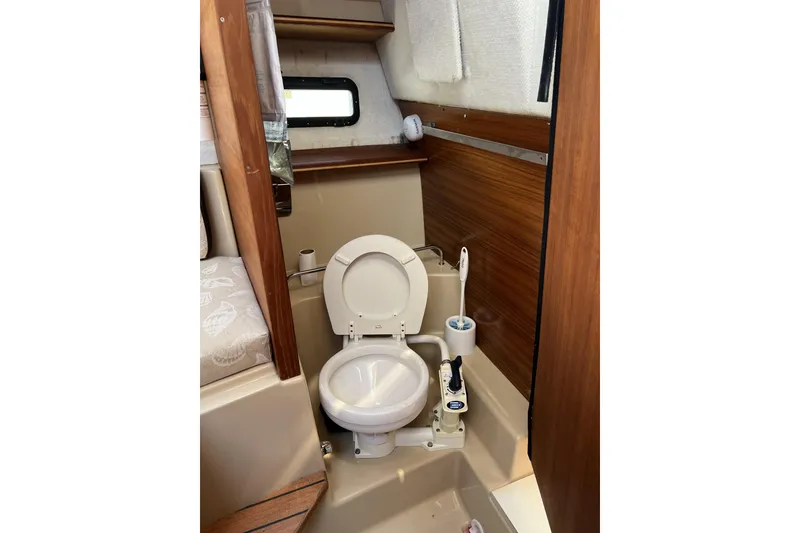 Slide: The Image of 2018 Ranger Tugs R-23 boat bathroom with toilet and wooden accents. - 33