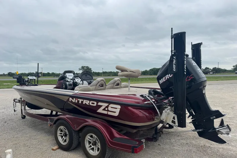 Slide: The Image of 2009 Nitro Z-9 CDC boat with Mercury engine on a trailer, parked outdoors. - 3