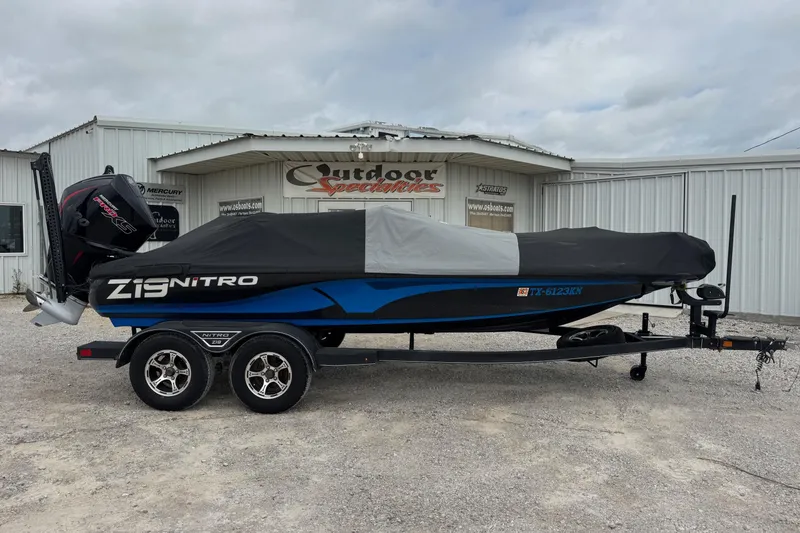 Slide: The Image of 2022 Nitro Z19 boat with cover on trailer, parked outside a dealership. - 12