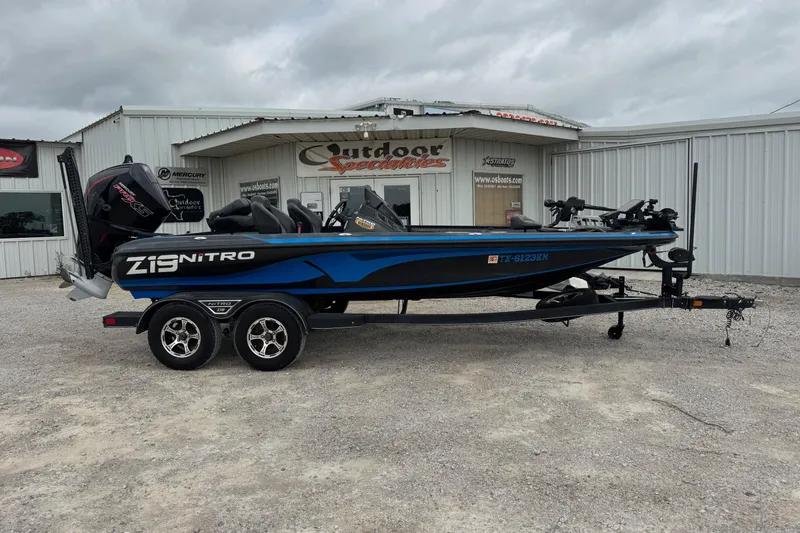 The Image of 2022 Nitro Z19 boat in blue and black, parked outside a dealership. - 4