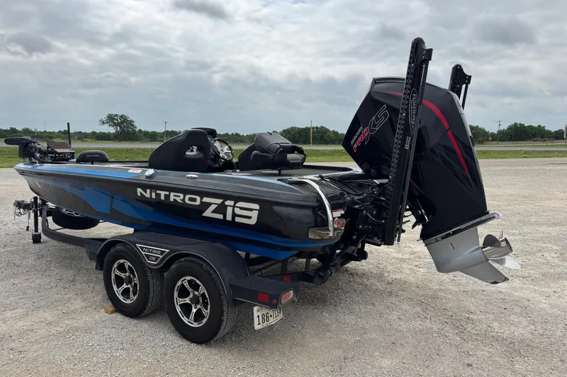 Slide: The Image of 2022 Nitro Z19 boat on trailer with powerful outboard motor, parked outdoors. - 8