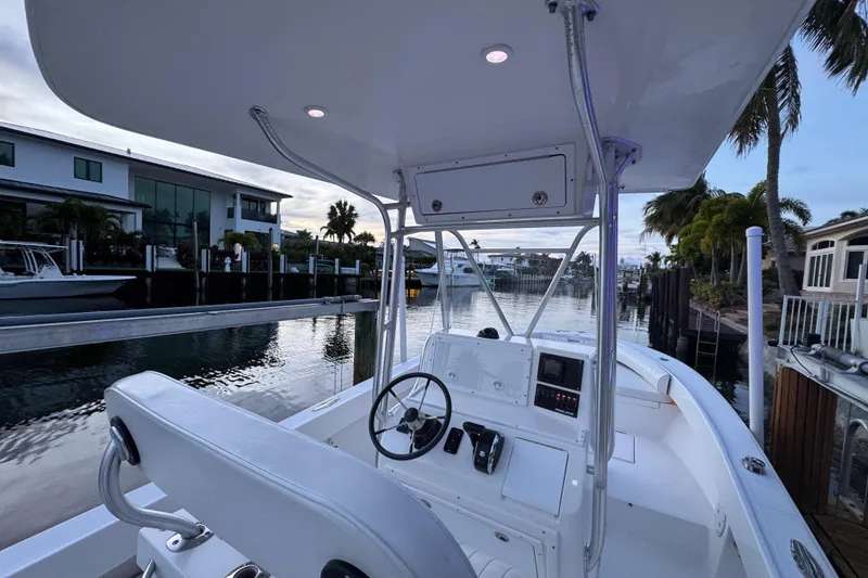 Slide: The Image of 2004 Regulator 21 Forward Seating boat docked by waterfront homes at sunset. - 10