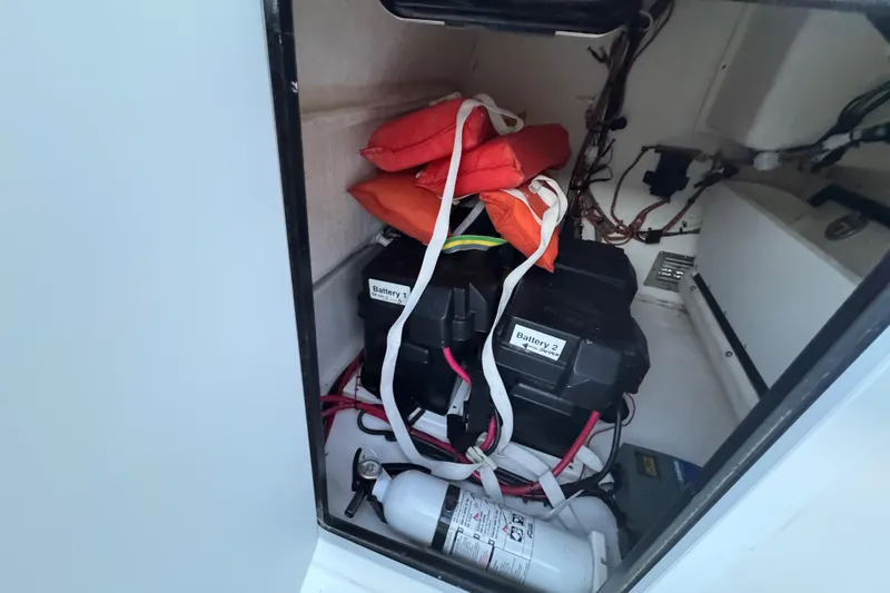 Slide: The Image of Storage compartment of 2004 Regulator 21 Forward Seating boat with batteries and life jackets. - 12