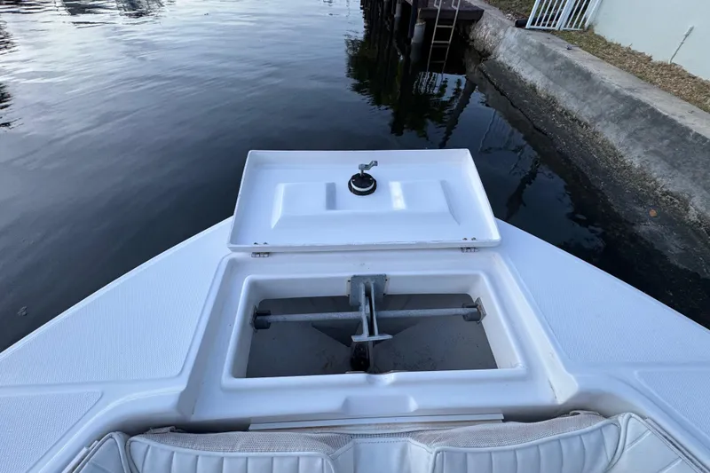 Slide: The Image of 2004 Regulator 21 Forward Seating boat with open anchor compartment by the water. - 18
