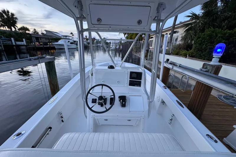 Slide: The Image of 2004 Regulator 21 Forward Seating boat docked in a serene canal setting. - 6