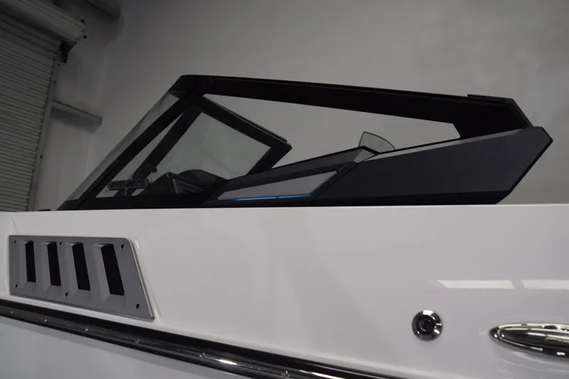 Slide: The Image of 2021 Supra SE 450 boat windshield and dashboard detail in a showroom setting. - 12