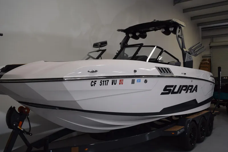 Slide: The Image of 2021 Supra SE 450 boat in showroom, white exterior, on trailer. - 3