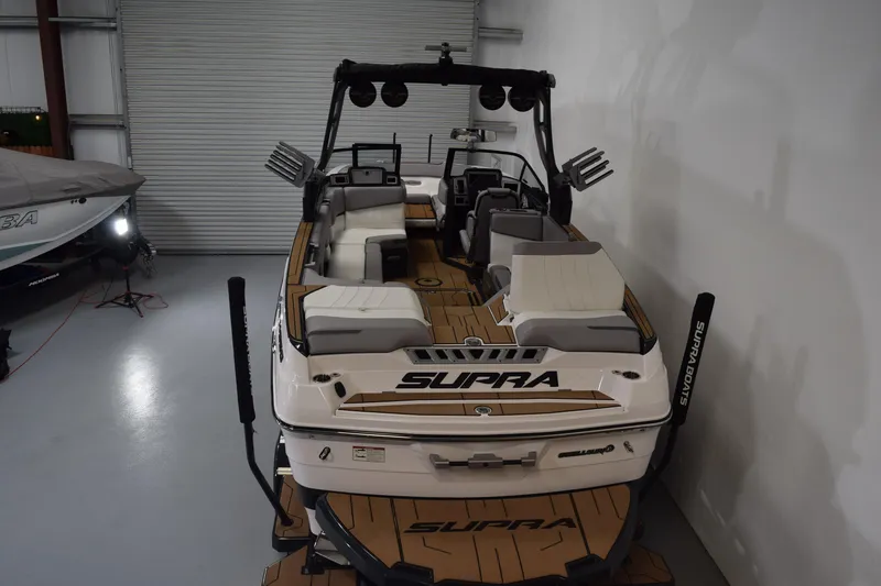Slide: The Image of 2021 Supra SE 450 boat in a garage, showcasing sleek design and spacious seating. - 9