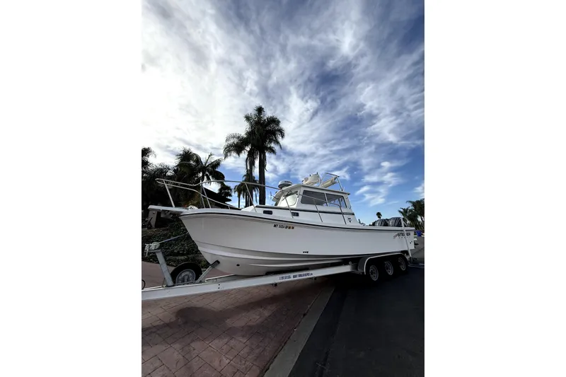 The Image of 2023 Steiger Craft 31 Fisherman boat on trailer under a partly cloudy sky. - 0