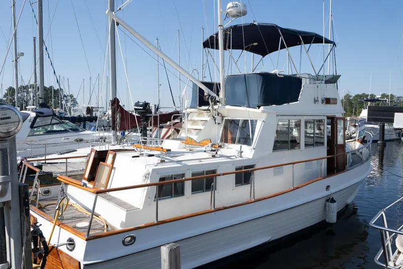 The Image of 1991 Grand Banks 36 Classic yacht docked at a marina under clear blue skies. - 1