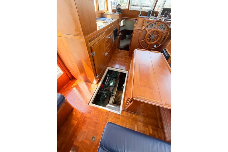 Slide: The Image of Interior of 1991 Grand Banks 36 Classic yacht with open engine hatch and wooden helm. - 104